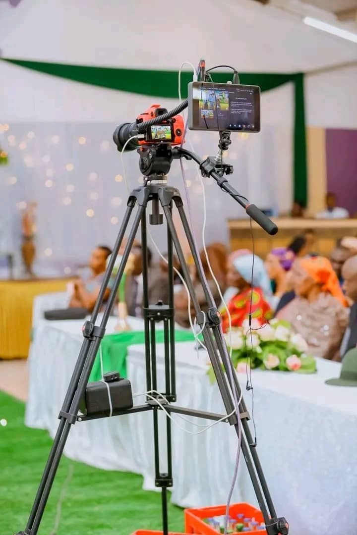 Video camera on a tripod filming a ceremony